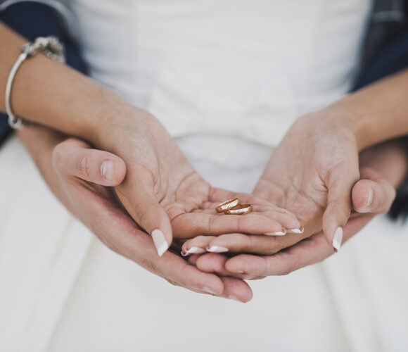 Bride and groom holding hands in hands.